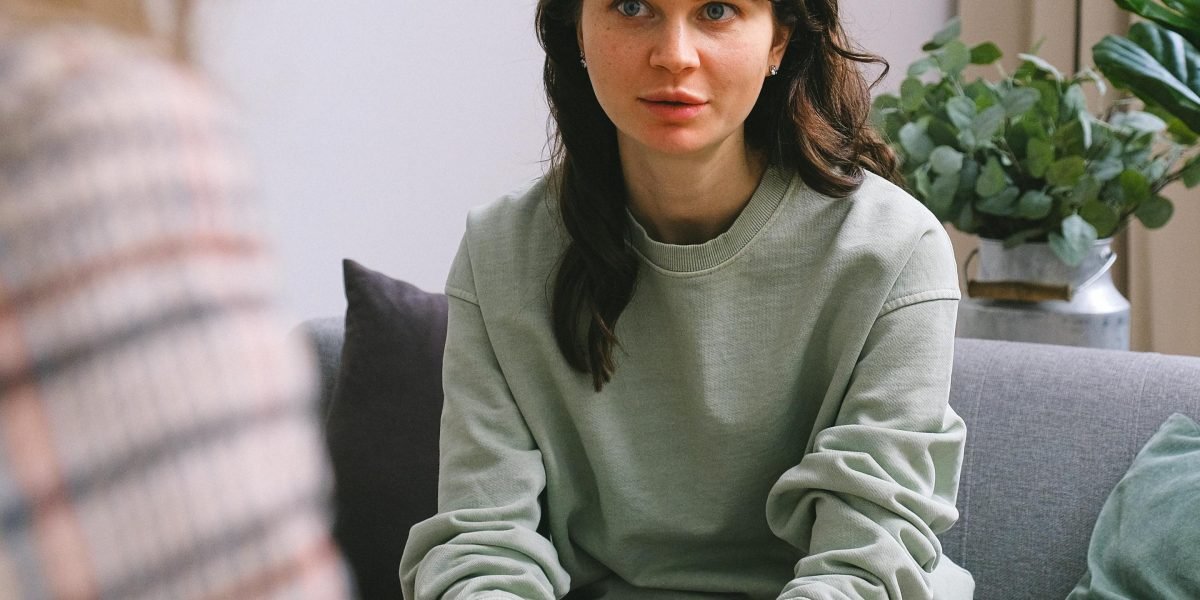 A therapist listens attentively to a client during a talk therapy session, emphasizing human connection in treatment.
