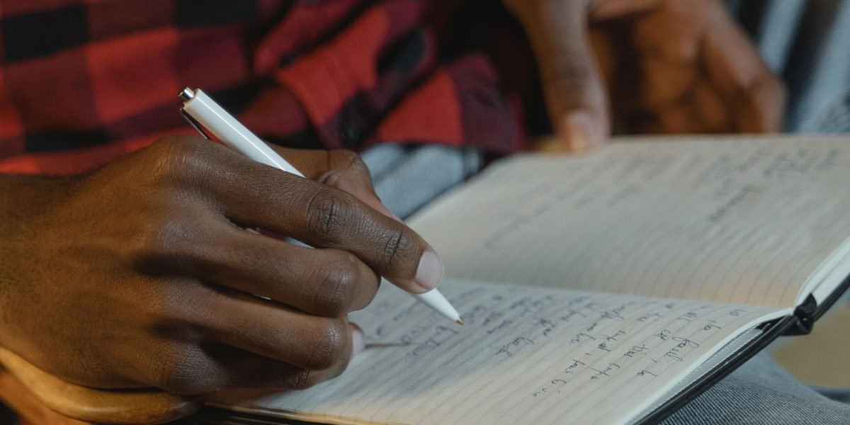 A person writing in a journal, embodying the act of self-reflection and gaining personal insight.