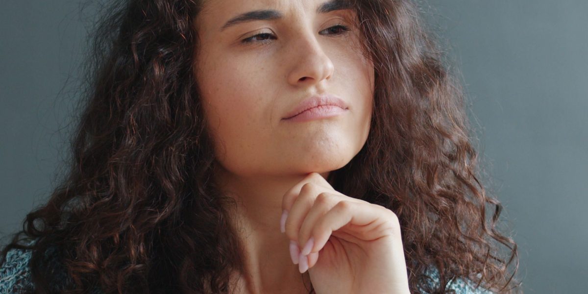 A person quietly reflects on their past experiences, contemplating family relationships and their impact.