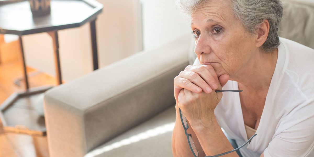 A person looks thoughtfully into the distance, pondering important decisions about their care.