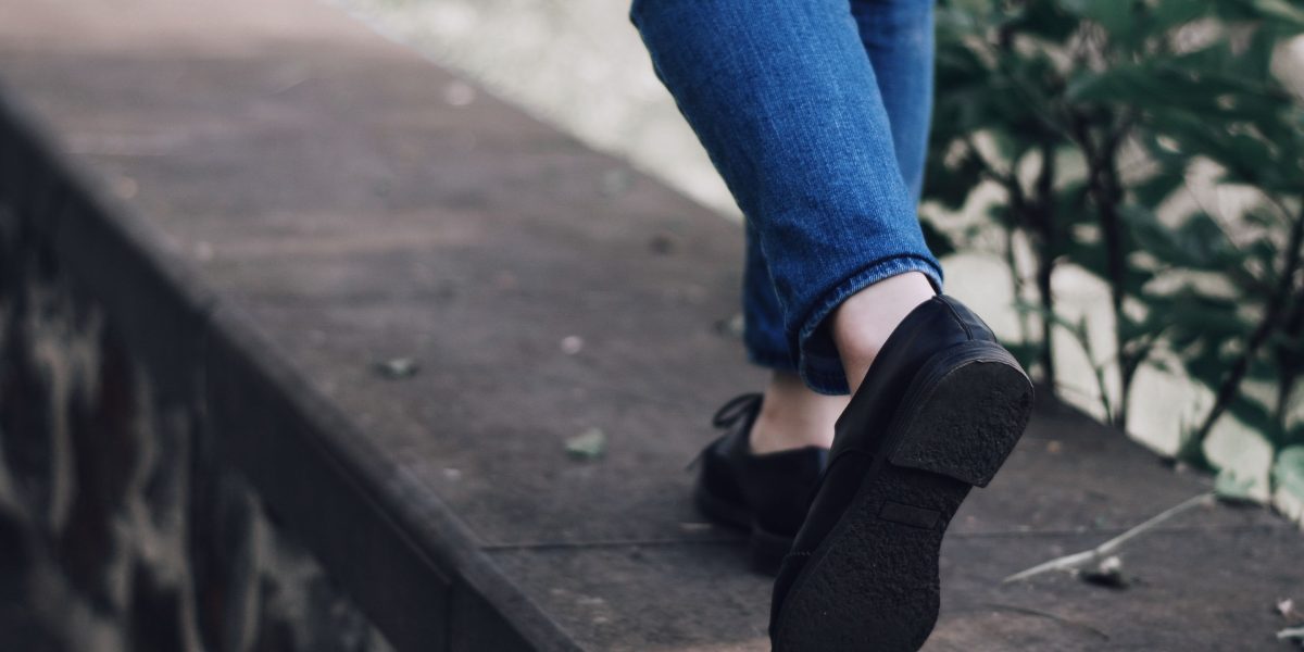 A person confidently taking a step forward, symbolizing overcoming obstacles and moving towards support.