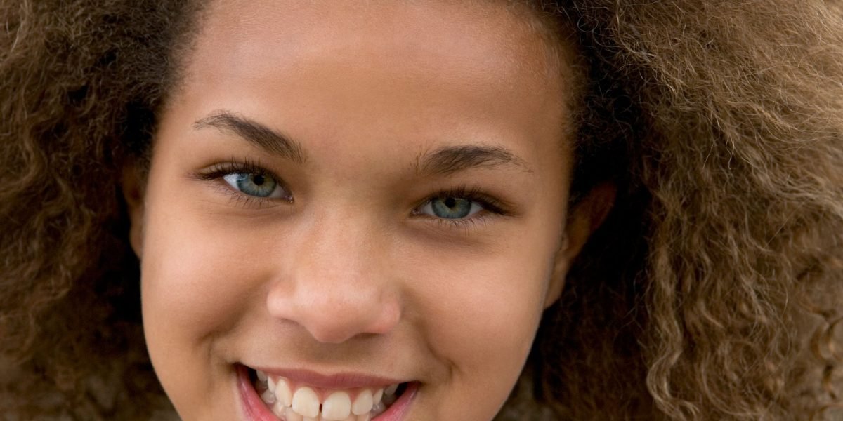 A confident teenager smiling outdoors, embodying the hope and positive outcomes achievable through self-help strategies and treatment.