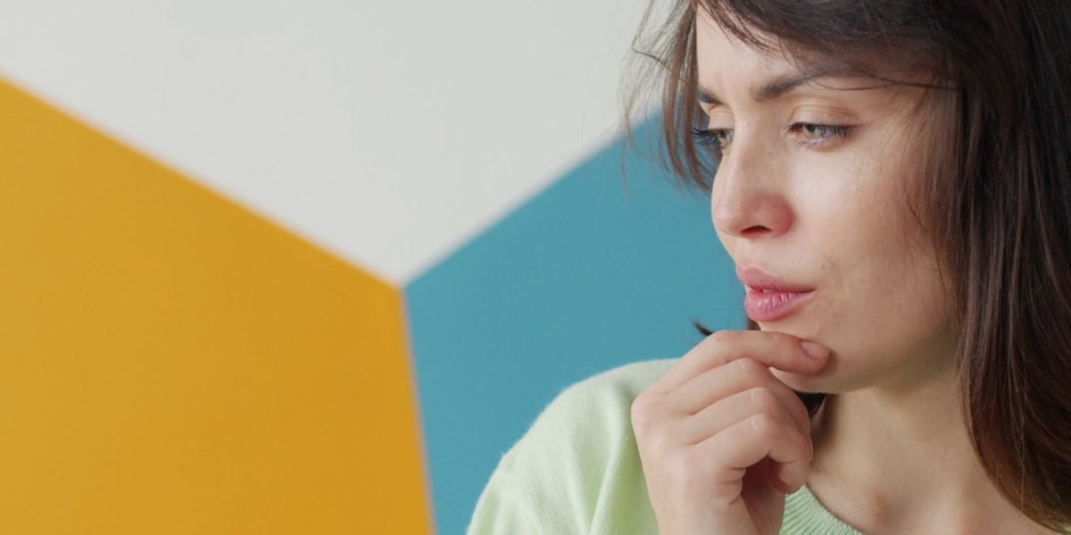 A person reflecting deeply, considering why different individuals respond uniquely to similar life challenges, symbolizing the core question addressed by the diathesis-stress model.