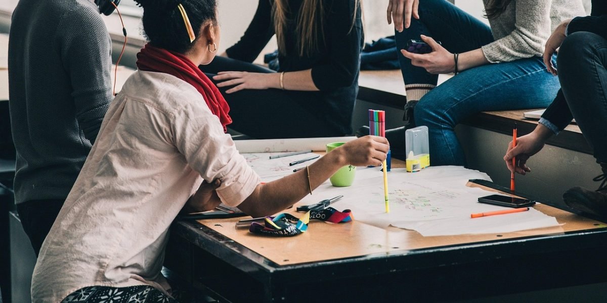 Individuals engaged in a hands-on activity in a class setting, fostering connection through shared learning rather than social pressure.