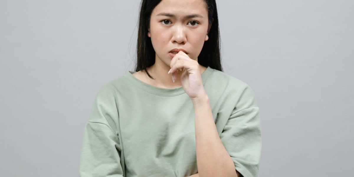 A person appears deep in thought, perhaps contemplating personal challenges or seeking solutions for well-being.