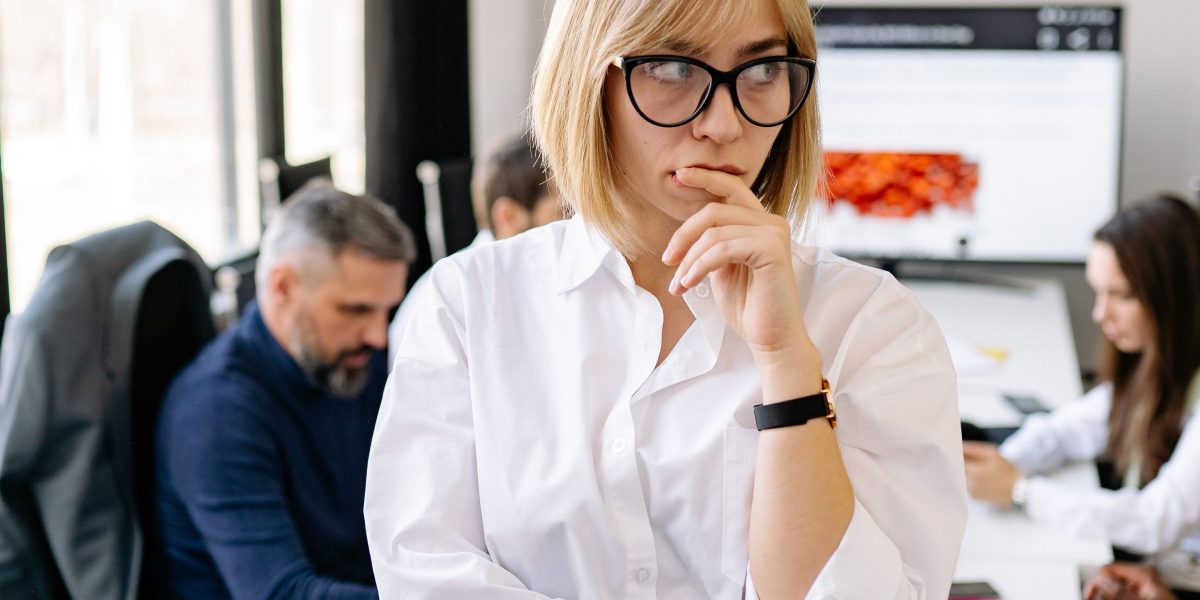 A woman thoughtfully considering options or questions, symbolizing the process of choosing the right online therapist.