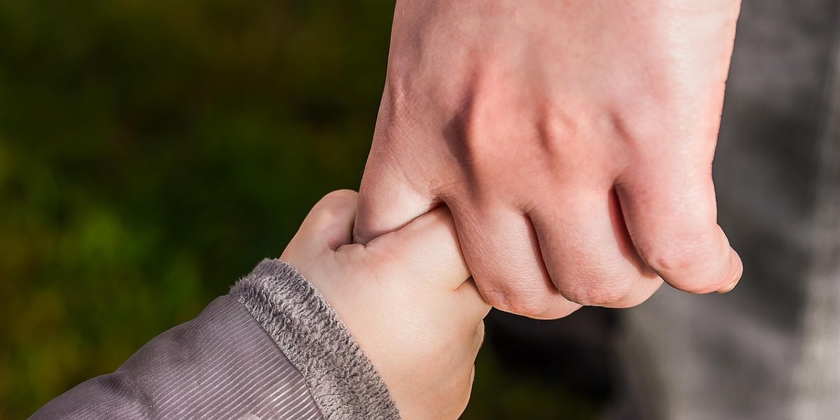 A therapist or caring adult providing calm, focused support to a child, possibly using visual aids or a comforting presence.
